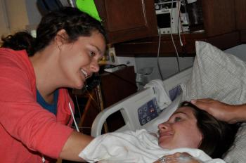A doula supports a laboring woman. 