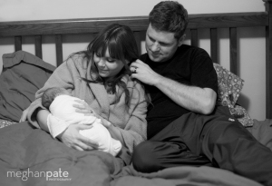 A new family snuggles in their own bed just after birth